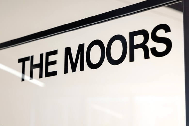 An image of "The Moors" window and door signage for a private office space.